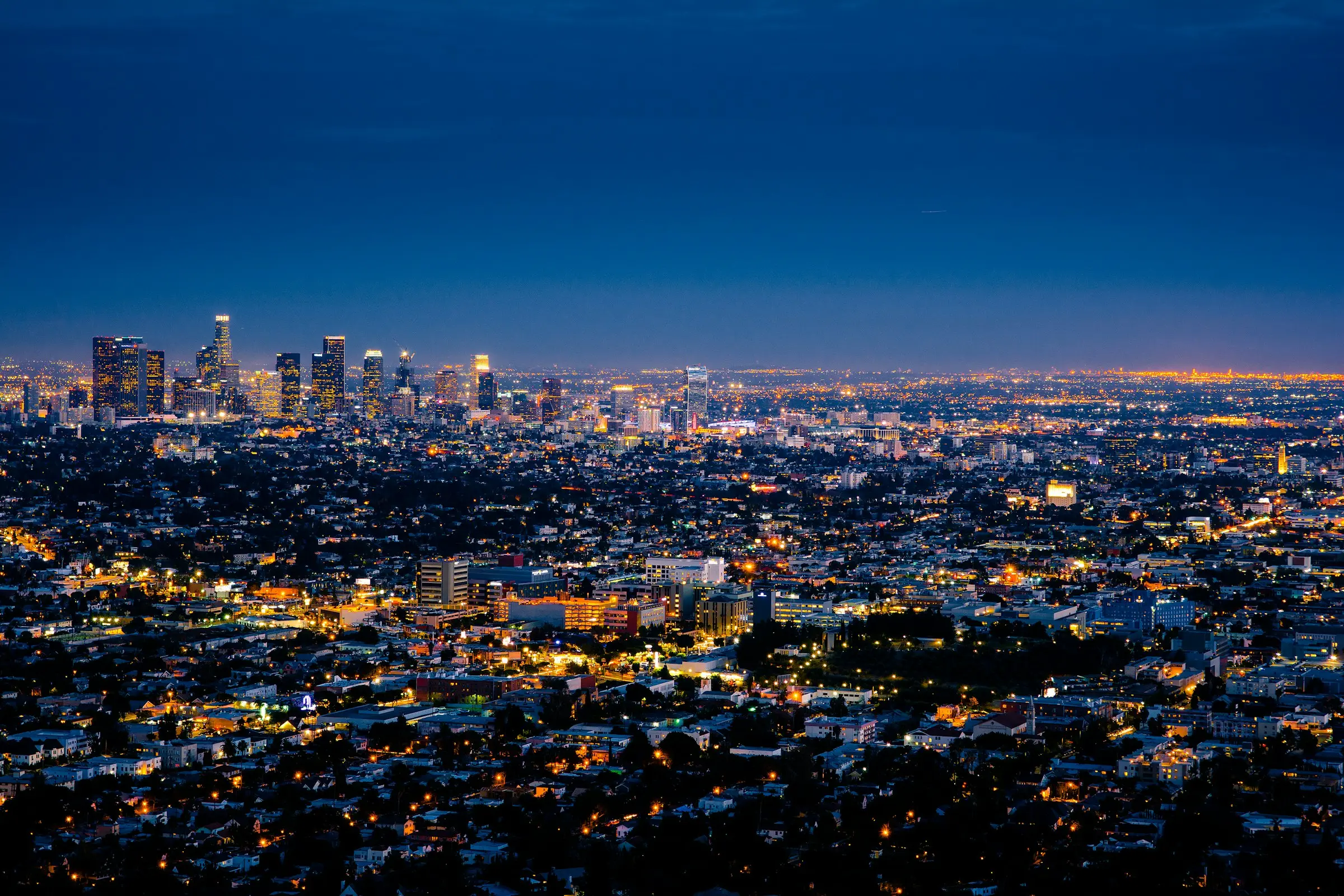 A city skyline rising through morning mist, seen from above
